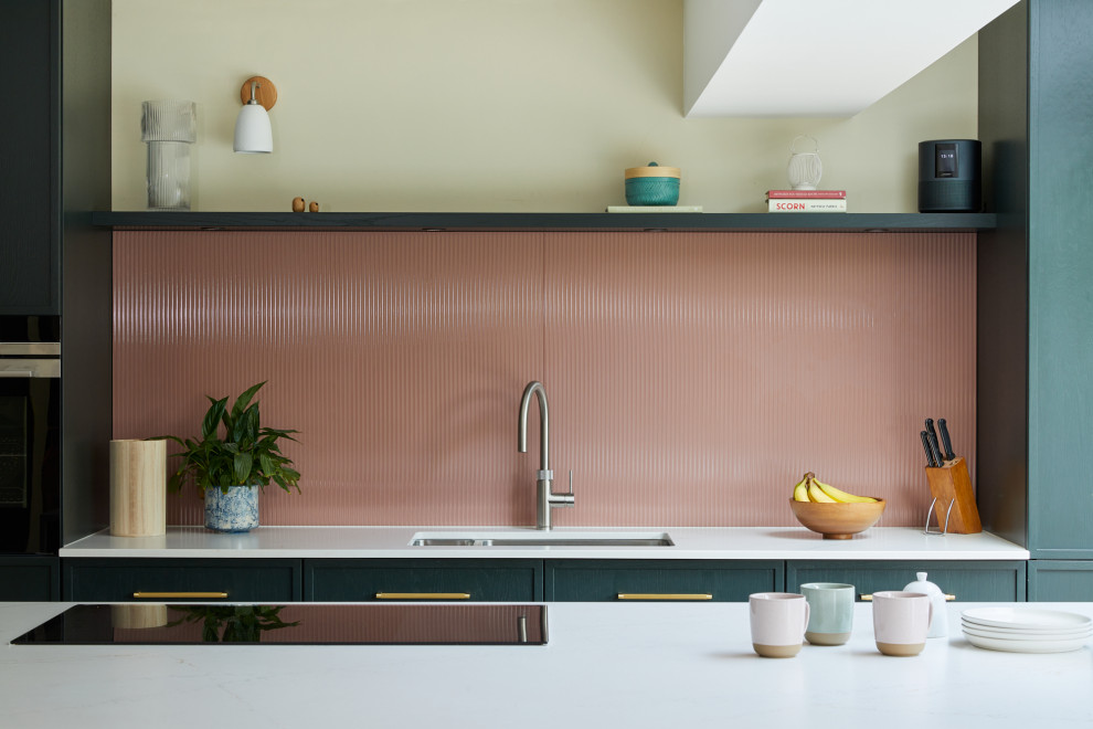 Esempio di una grande cucina design con ante con riquadro incassato, ante verdi, top in quarzo composito, paraspruzzi rosa, paraspruzzi con lastra di vetro, elettrodomestici in acciaio inossidabile e top bianco