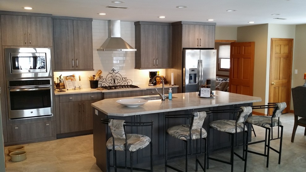 Example of a mid-sized transitional ceramic tile eat-in kitchen design in St Louis with an undermount sink, flat-panel cabinets, gray cabinets, quartzite countertops, white backsplash, ceramic backsplash, stainless steel appliances and an island