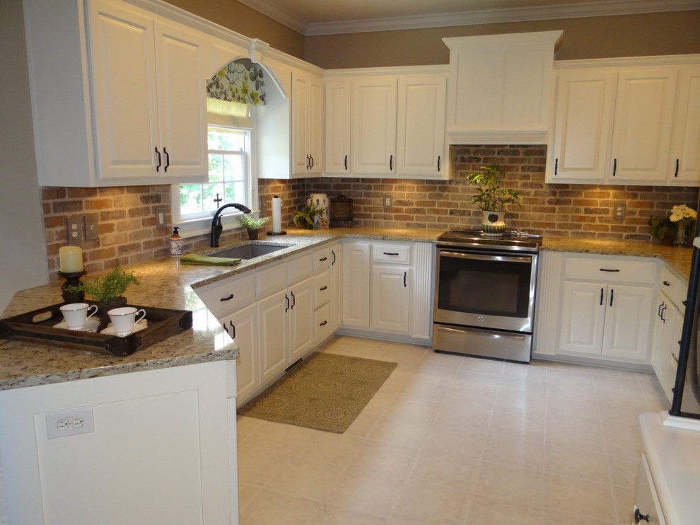 Mid-sized traditional u-shaped separate kitchen in Atlanta with an undermount sink, raised-panel cabinets, white cabinets, granite benchtops, brown splashback, brick splashback, stainless steel appliances, laminate floors, no island, beige floor and beige benchtop.