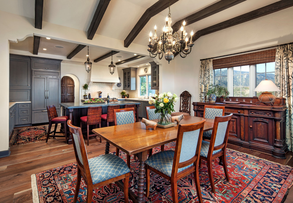 This is an example of a mid-sized mediterranean kitchen/dining combo in Santa Barbara with white walls, dark hardwood floors and no fireplace.