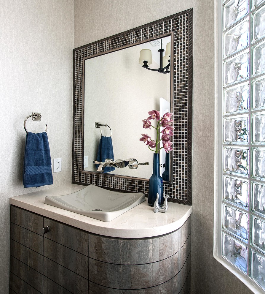 Bathroom - mid-sized transitional brown tile and mosaic tile medium tone wood floor bathroom idea in Denver with a vessel sink, flat-panel cabinets, distressed cabinets, marble countertops, a two-piece toilet and beige walls