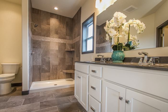 Inspiration for a mid-sized transitional master porcelain tile and brown tile porcelain tile and brown floor alcove shower remodel in Cedar Rapids with shaker cabinets, white cabinets, marble countertops, gray walls, a two-piece toilet and an undermount sink