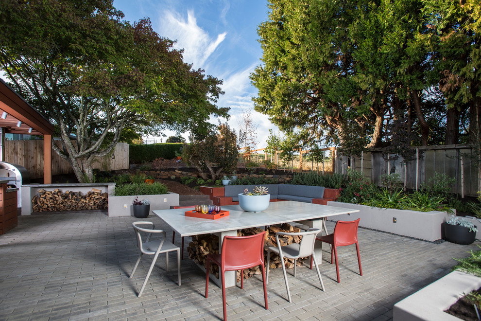This is an example of a large contemporary backyard patio in Portland with concrete pavers, no cover and an outdoor kitchen.