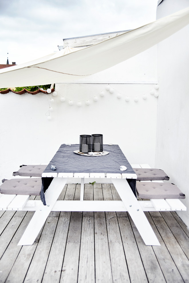 Mid-sized scandinavian deck in Other with an awning.