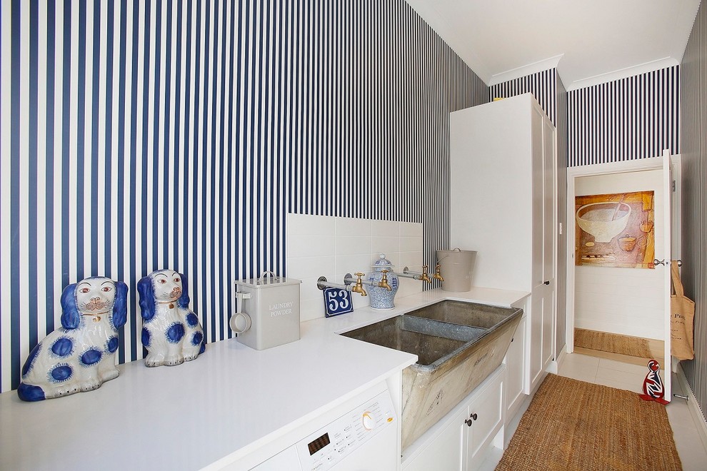 Design ideas for a small country galley dedicated laundry room in Other with a farmhouse sink, shaker cabinets, white cabinets, multi-coloured walls, ceramic floors, a side-by-side washer and dryer, white floor and white benchtop.