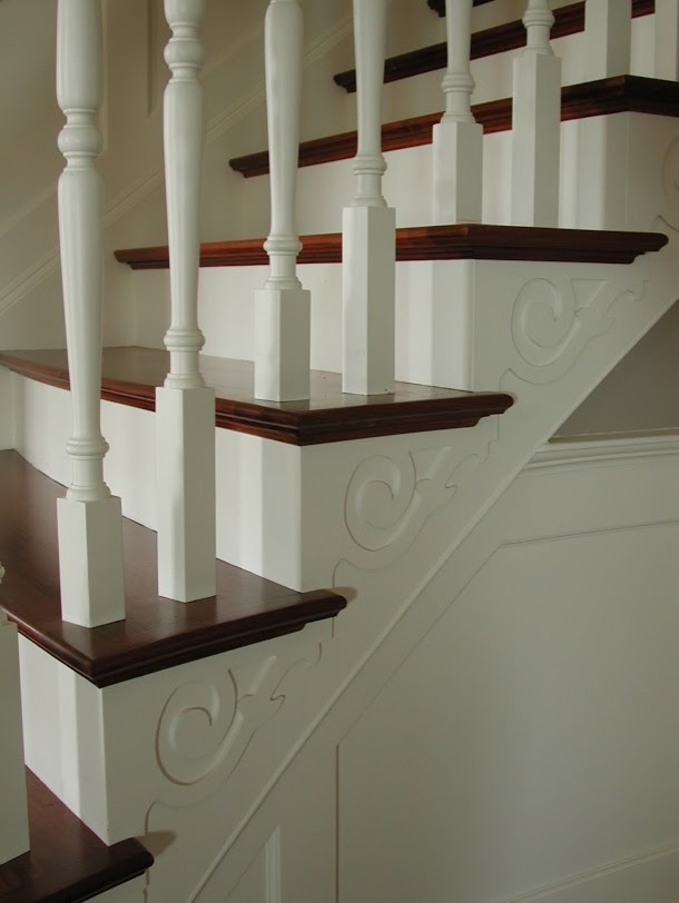 Photo of a mid-sized traditional wood straight staircase in Seattle with painted wood risers and wood railing.