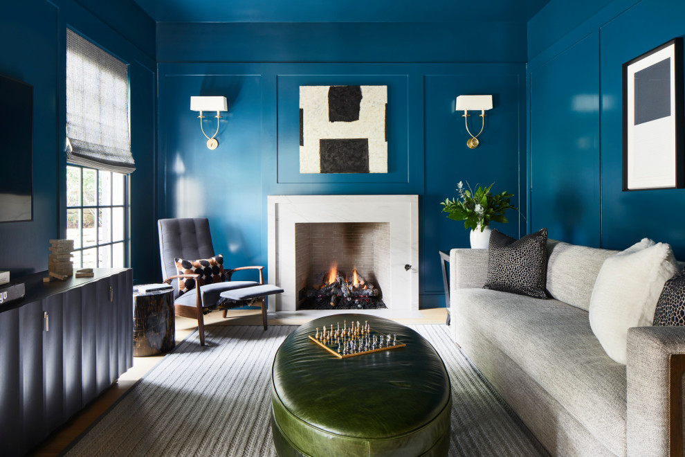 オースティンにある広いトランジショナルスタイルのおしゃれな書斎 (青い壁、淡色無垢フローリング、標準型暖炉、石材の暖炉まわり、造り付け机) の写真