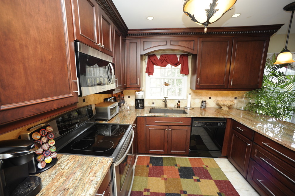 Inspiration for a mid-sized transitional u-shaped limestone floor enclosed kitchen remodel in Baltimore with an undermount sink, beaded inset cabinets, dark wood cabinets, granite countertops, beige backsplash, stone tile backsplash, stainless steel appliances and a peninsula