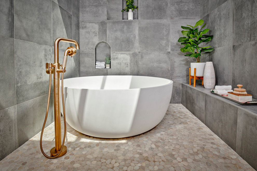 Свежая идея для дизайна: большая главная ванная комната в современном стиле с отдельно стоящей ванной, серой плиткой, керамогранитной плиткой, полом из галечной плитки, нишей, душевой комнатой и бежевым полом - отличное фото интерьера