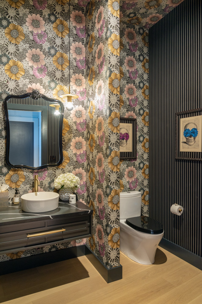 Photo of a mid-sized contemporary powder room in Seattle with black benchtops, bamboo floors and wallpaper.