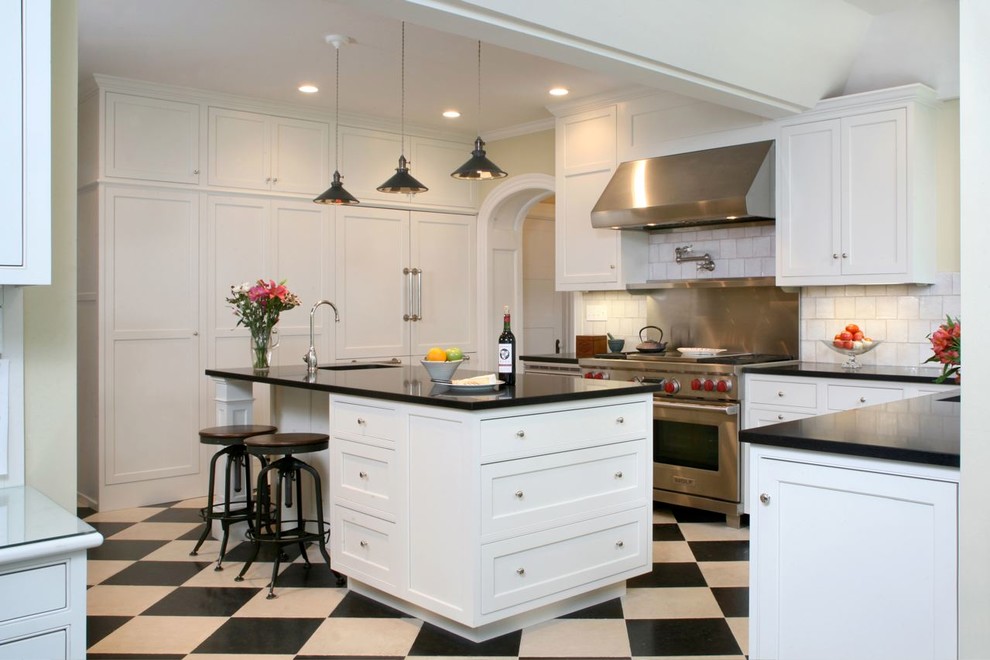 Traditional l-shaped eat-in kitchen in Boston with an undermount sink, beaded inset cabinets, white cabinets, white splashback and stainless steel appliances.