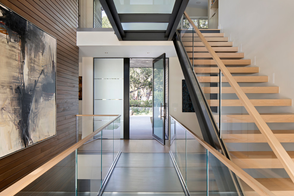 Photo of a contemporary entryway in San Francisco with white walls, a pivot front door and a glass front door.