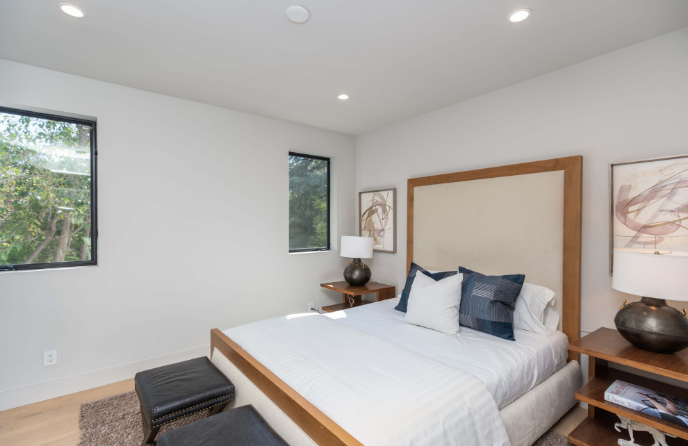 Großes Modernes Gästezimmer ohne Kamin mit weißer Wandfarbe, hellem Holzboden und beigem Boden in Los Angeles