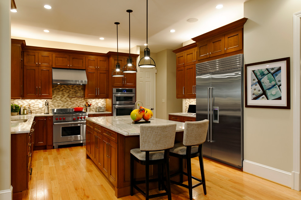Design ideas for a traditional kitchen in DC Metro with an undermount sink, recessed-panel cabinets, medium wood cabinets, beige splashback, stainless steel appliances and medium hardwood floors.