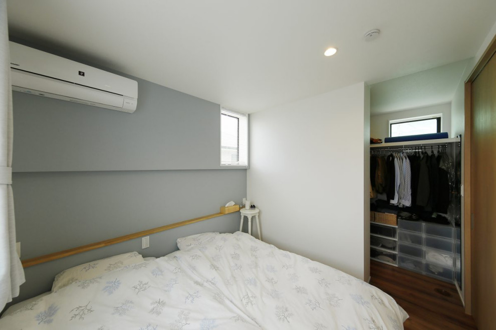 Mid-sized industrial master bedroom in Tokyo Suburbs with grey walls, dark hardwood floors, brown floor, wallpaper and wallpaper.
