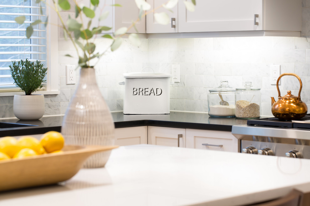 Example of a mid-sized transitional l-shaped light wood floor and brown floor eat-in kitchen design in Seattle with an undermount sink, shaker cabinets, white cabinets, quartz countertops, multicolored backsplash, marble backsplash, stainless steel appliances and an island