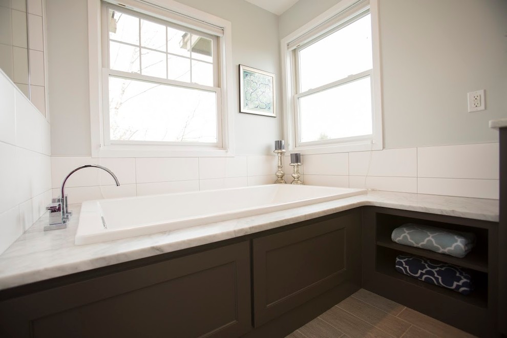 This is an example of a large contemporary master bathroom in Minneapolis with shaker cabinets, dark wood cabinets, an alcove tub, a corner shower, a one-piece toilet, beige tile, blue tile, gray tile, multi-coloured tile, matchstick tile, grey walls, painted wood floors and an undermount sink.