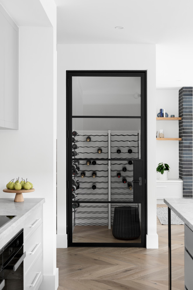 Design ideas for a large contemporary wine cellar in Melbourne with medium hardwood floors, storage racks and brown floor.