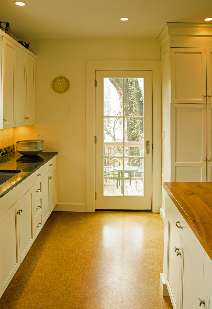 Large transitional l-shaped cork floor eat-in kitchen photo in Boston with an undermount sink, shaker cabinets, white cabinets, soapstone countertops, green backsplash, ceramic backsplash, stainless steel appliances and an island