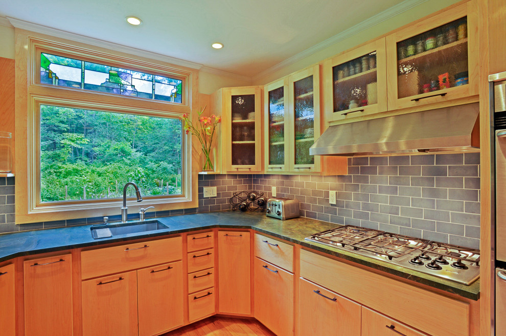 Eclectic u-shaped medium tone wood floor kitchen photo in Boston with an undermount sink, glass-front cabinets, light wood cabinets, granite countertops, blue backsplash, ceramic backsplash, stainless steel appliances, no island and green countertops