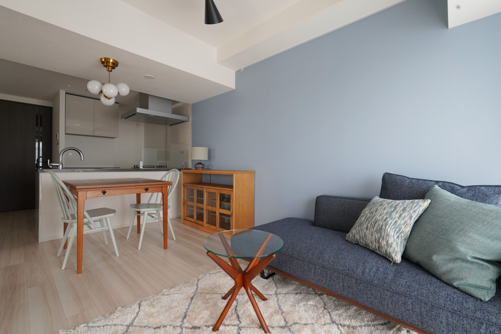 Пример оригинального дизайна: гостиная комната в стиле кантри с синими стенами и светлым паркетным полом