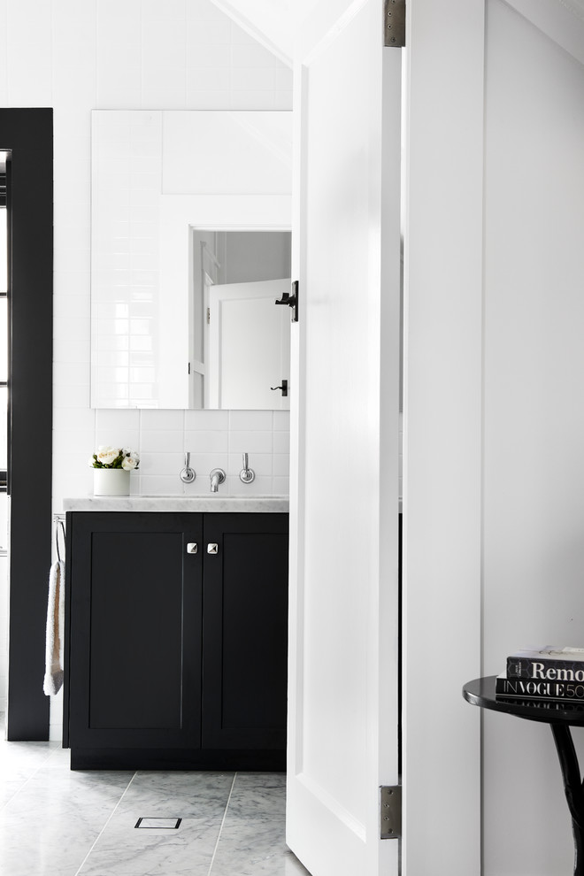 Mid-sized transitional kids bathroom in Sydney with shaker cabinets, black cabinets, a corner shower, a one-piece toilet, white tile, porcelain tile, white walls, marble floors, an undermount sink, marble benchtops and a hinged shower door.