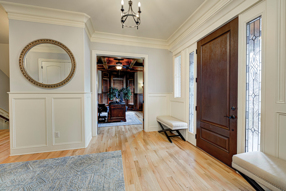 Foto de puerta principal clásica renovada de tamaño medio con suelo de madera en tonos medios, puerta simple, paredes grises, puerta de madera oscura y suelo beige