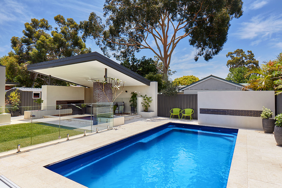 Mid-sized contemporary backyard rectangular pool in Perth with natural stone pavers.