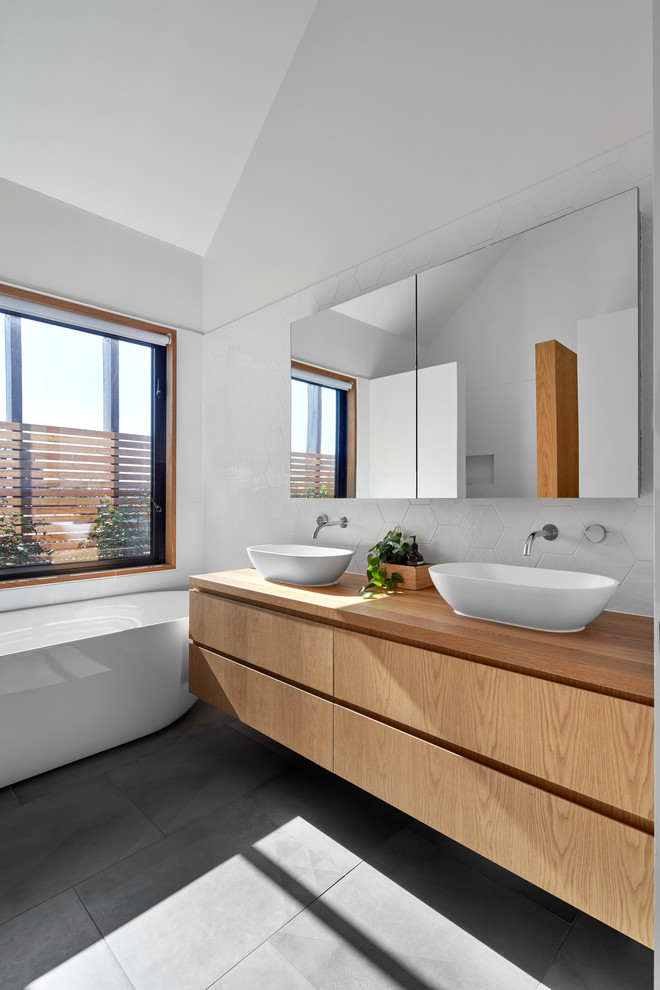 This is an example of a contemporary master bathroom in Melbourne with marble benchtops.
