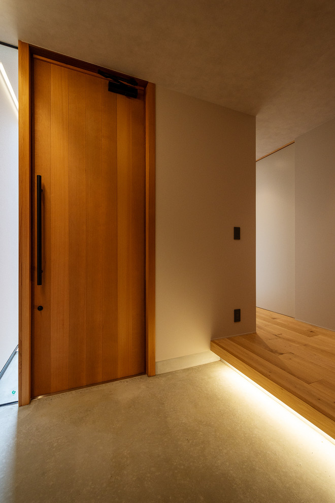 Inspiration för mellanstora minimalistiska hallar, med vita väggar, mellanmörkt trägolv, en enkeldörr, mellanmörk trädörr och beiget golv