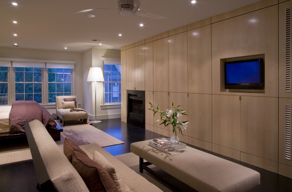 Modern bedroom in DC Metro with beige walls, dark hardwood floors, a standard fireplace and brown floor.