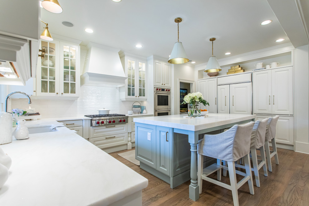 Design ideas for a transitional kitchen in Atlanta with an undermount sink, white splashback, stainless steel appliances, medium hardwood floors, with island, brown floor and white benchtop.