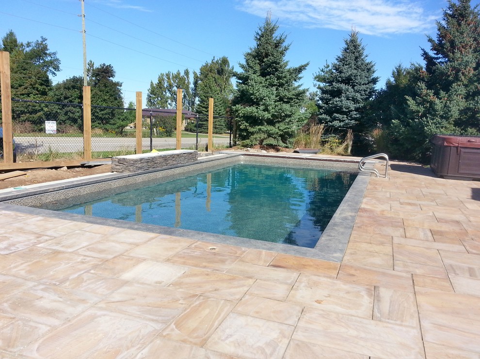 This is an example of a large mediterranean pool in Toronto with a water feature.