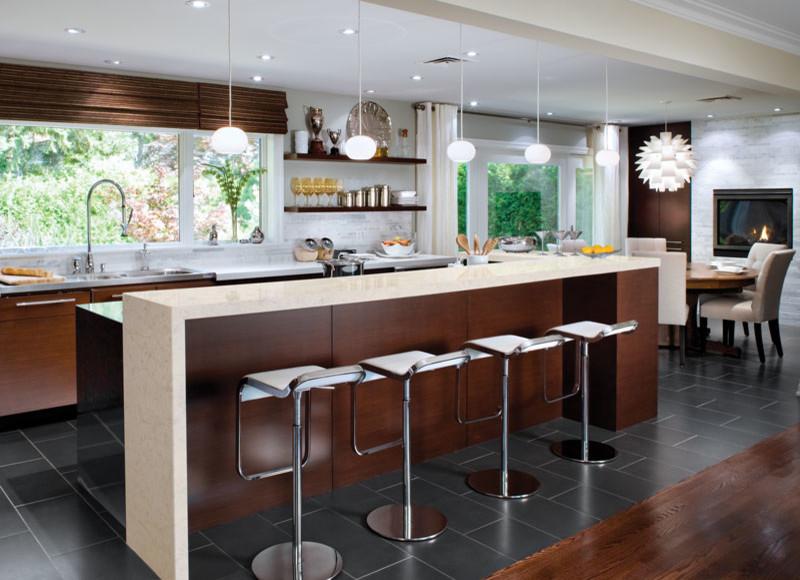 This is an example of a contemporary single-wall kitchen in Raleigh with medium wood cabinets, quartz benchtops, stainless steel appliances and with island.