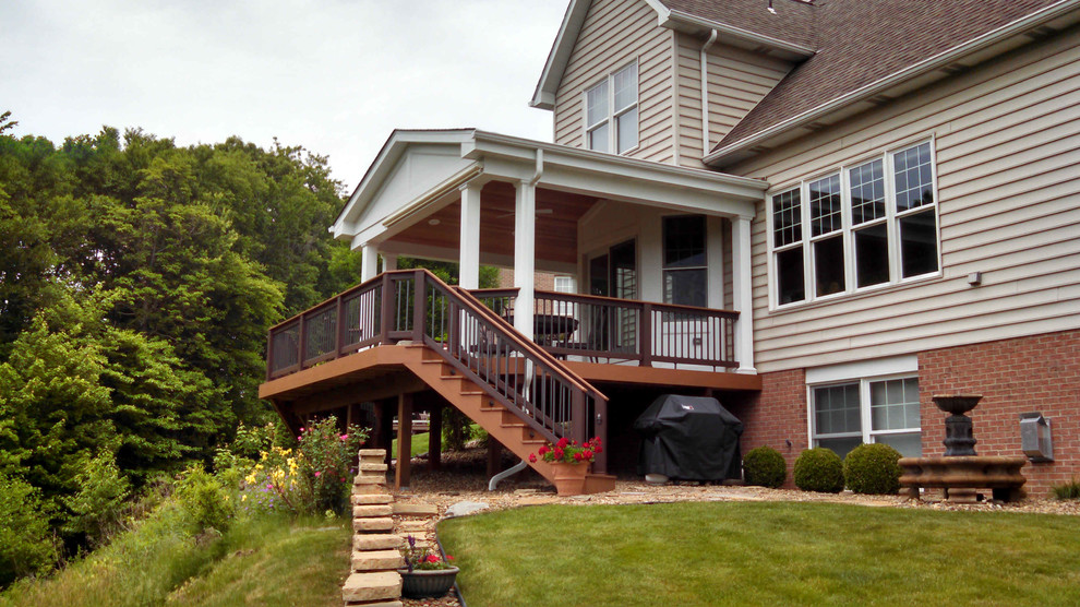 Inspiration for a mid-sized timeless backyard deck remodel with a roof extension