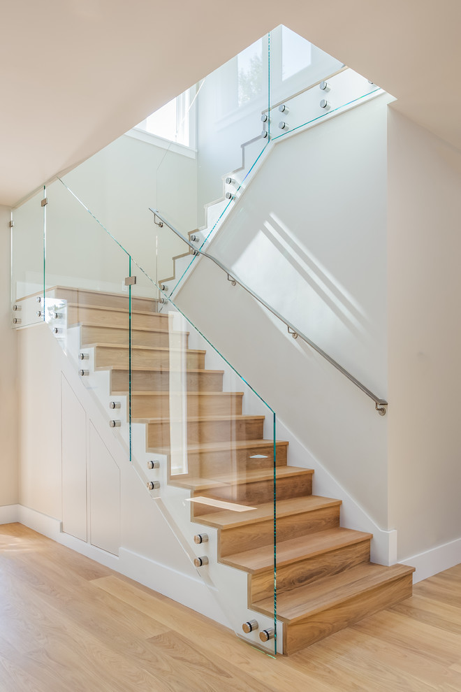 Photo of a mid-sized transitional wood u-shaped staircase in San Francisco with glass railing.