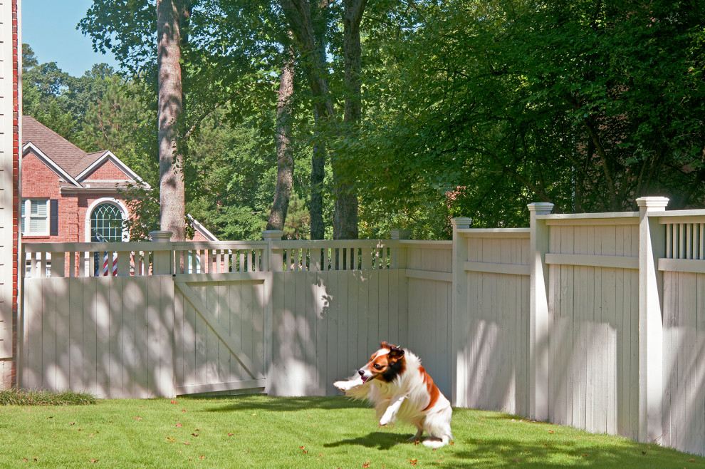 Réalisation d'un grand jardin arrière tradition avec une clôture en bois.
