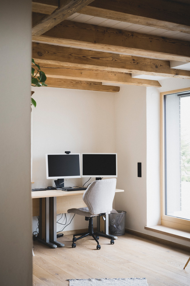 Rustikaler Flur mit weißer Wandfarbe, gebeiztem Holzboden, braunem Boden und freigelegten Dachbalken in Nürnberg