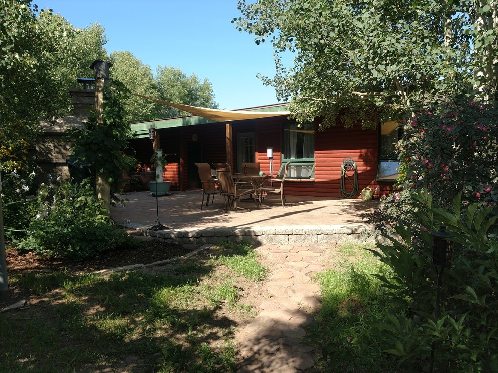 Mittelgroßer Rustikaler Patio hinter dem Haus mit Outdoor-Küche, Natursteinplatten und Markisen in Sonstige