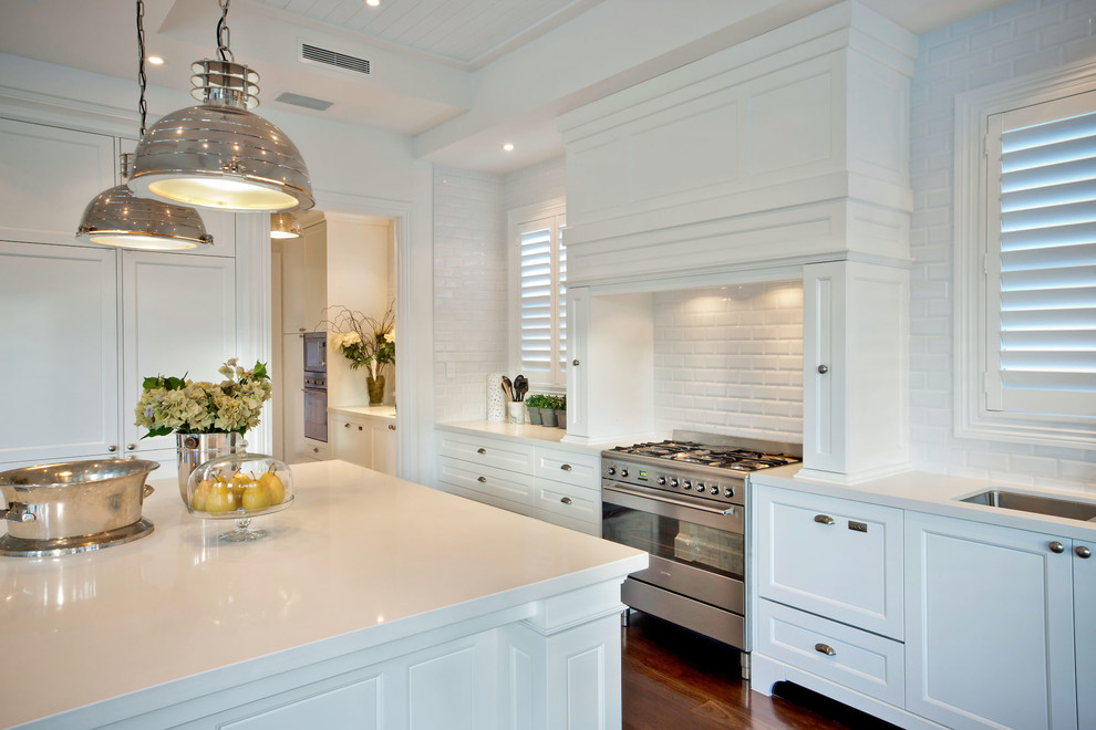 Inspiration for a large traditional eat-in kitchen in Brisbane with an undermount sink, recessed-panel cabinets, white cabinets, quartz benchtops, white splashback, subway tile splashback, stainless steel appliances, medium hardwood floors and with island.
