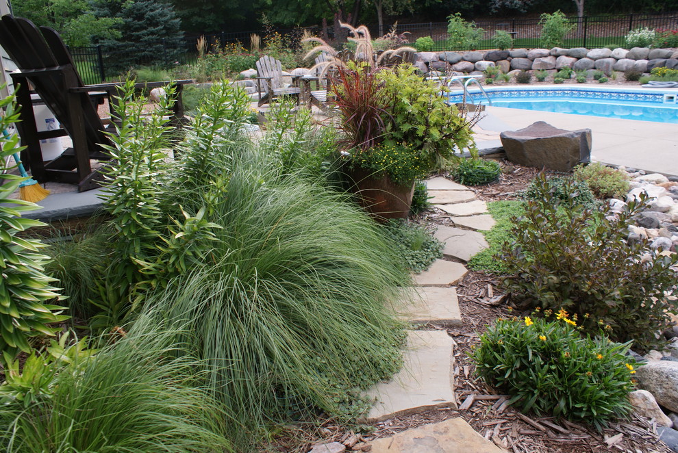 Photo of a mid-sized traditional backyard garden in Minneapolis with a garden path and natural stone pavers.