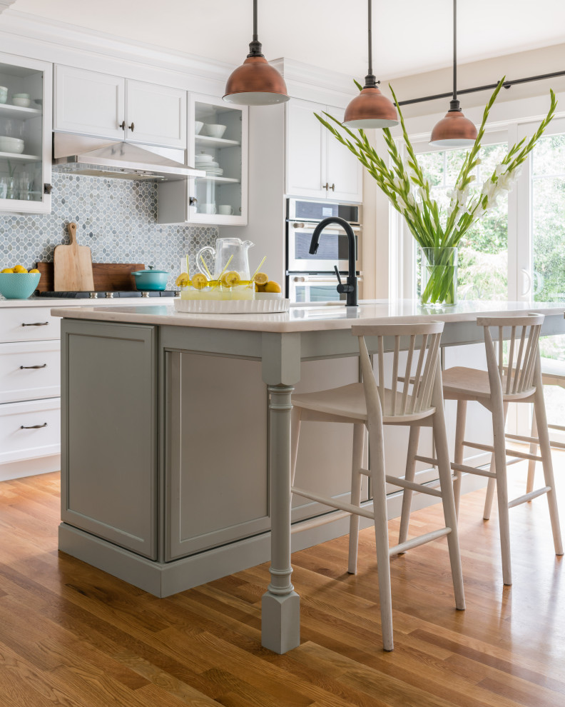 Example of a mid-sized galley light wood floor kitchen design in Boston with shaker cabinets, white cabinets, blue backsplash, ceramic backsplash, stainless steel appliances and white countertops