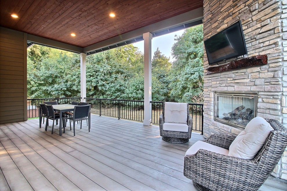 Inspiration for an expansive traditional backyard deck in Portland with a fire feature and a roof extension.