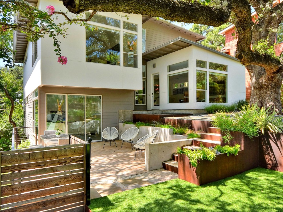This is an example of a contemporary split-level white exterior in Austin with a shed roof.