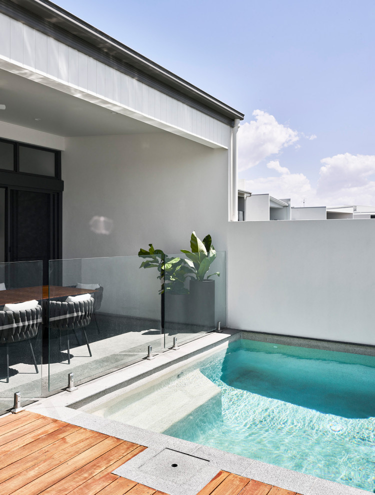 Design ideas for a small modern backyard rectangular pool in Sunshine Coast with decking.