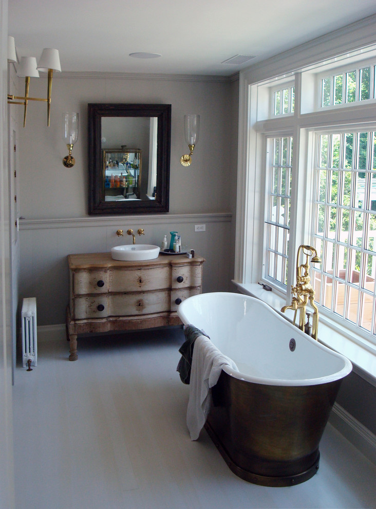 Inspiration for a large traditional master bathroom in New York with a freestanding tub, grey walls and light hardwood floors.