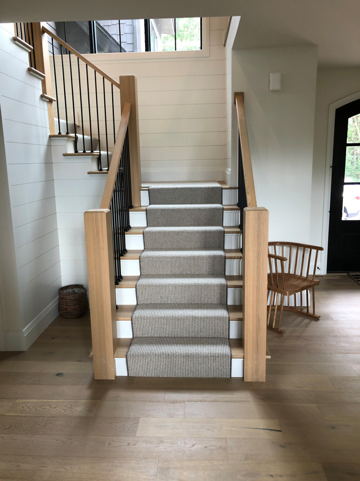 Свежая идея для дизайна: угловая лестница в стиле кантри с ступенями с ковровым покрытием, деревянными перилами и стенами из вагонки - отличное фото интерьера