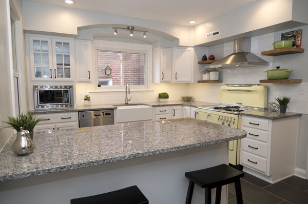 Small modern l-shaped separate kitchen in Baltimore with a farmhouse sink, recessed-panel cabinets, white cabinets, granite benchtops, yellow splashback, ceramic splashback, stainless steel appliances, porcelain floors, a peninsula and grey floor.