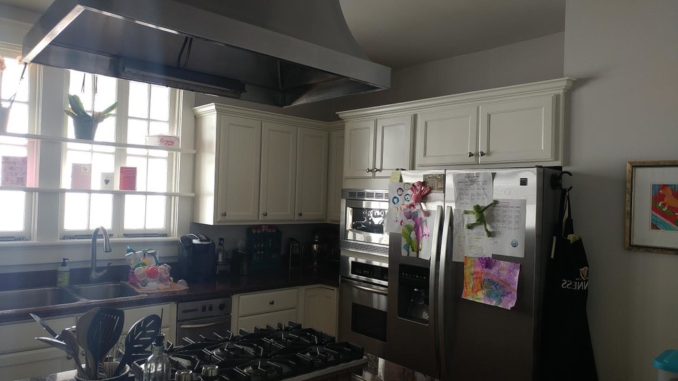 Mid-sized transitional l-shaped dark wood floor enclosed kitchen photo in Charlotte with a double-bowl sink, shaker cabinets, white cabinets, granite countertops, stainless steel appliances and an island
