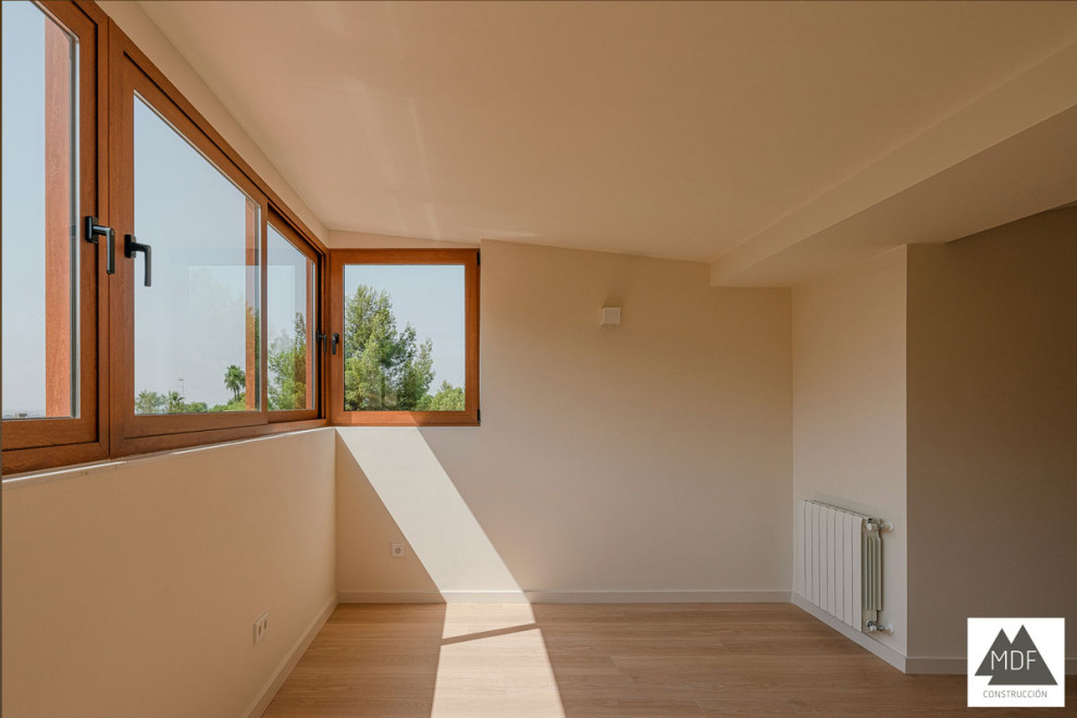 Ejemplo de despacho mediterráneo grande con paredes blancas, suelo de madera clara y suelo marrón